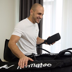 Klijent prima Normatec 3.0 terapiju, kompresioni tretman koji poboljšava cirkulaciju i ubrzava oporavak mišića